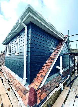 Dormer loft conversion clad in dark weatherboard